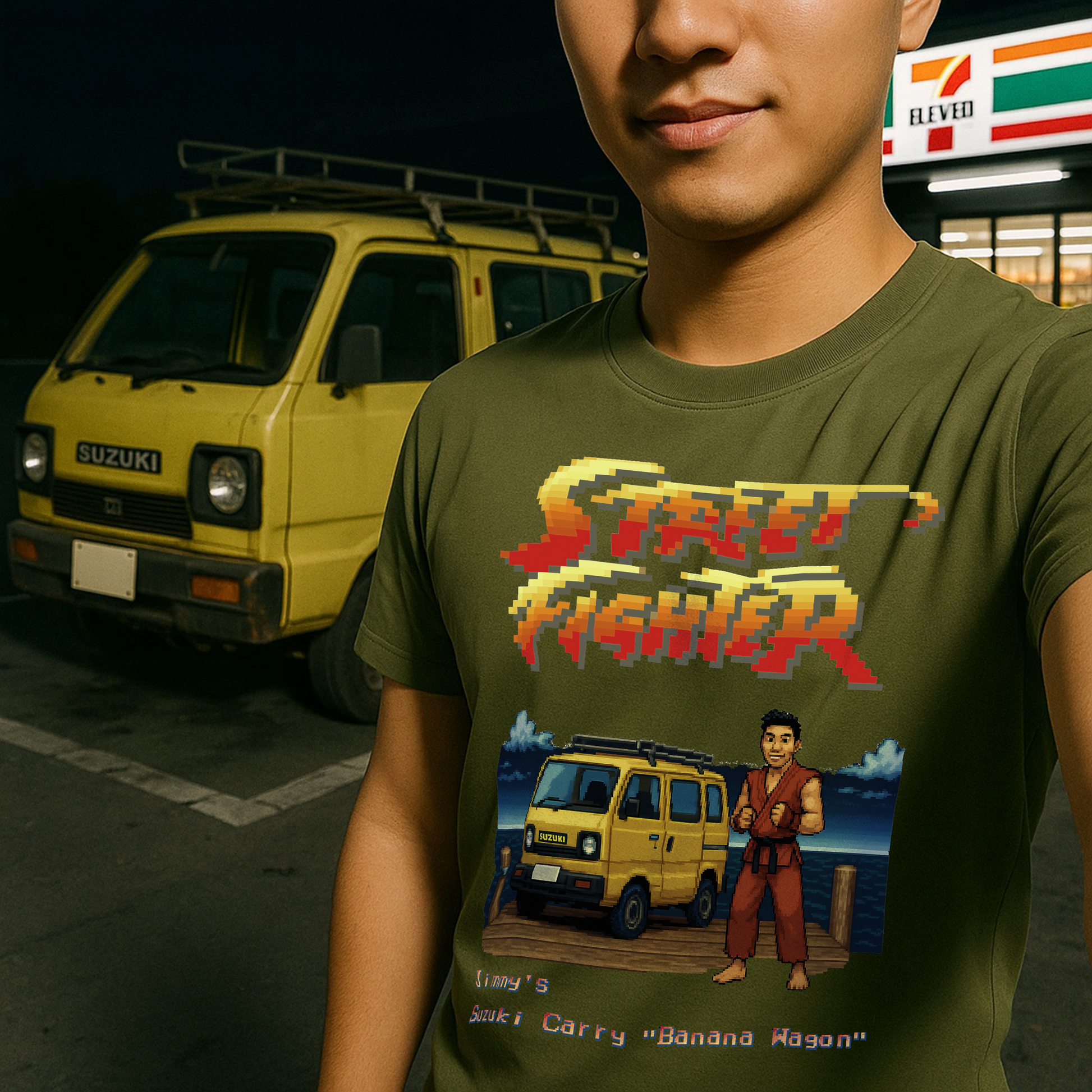 Olive green Street Fighter II pixel art T-shirt featuring custom 16-bit design of a yellow Suzuki Carry van and Ryu-inspired character. Text reads "Jimmy’s Suzuki Carry 'Banana Wagon'." Modeled by young man standing in front of a real Suzuki Carry outside a 7-Eleven. Perfect gift for retro gamers and JDM car lovers.