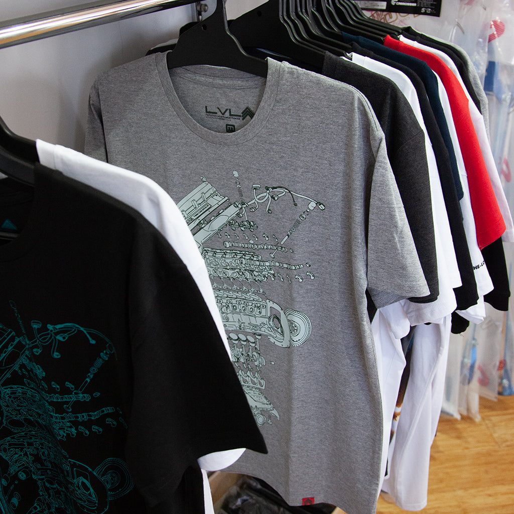 Level UP Nissan RB26 engine diagram T-shirt in grey hung up on a rack in a JDM wares retail store